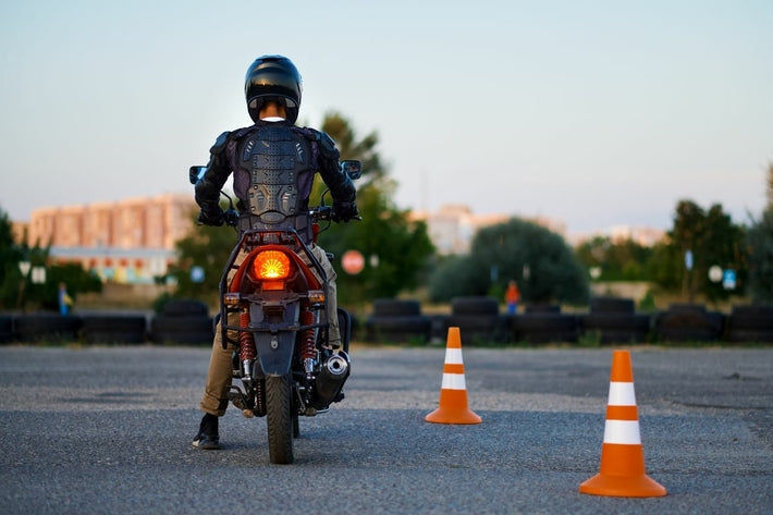 Motard de dos sur son deux-roues lors de l épreuve pratique du permis moto sur un plateau