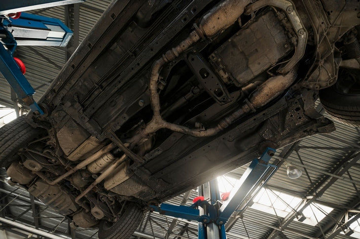 Vue de dessous du chassis de voiture sur un pont elevateur en atelier
