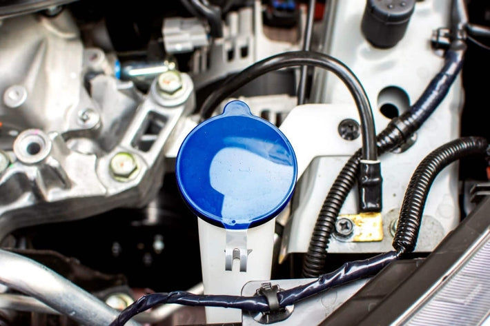 Bouchon bleu du réservoir de liquide lave-glace dans le compartiment moteur d'une voiture