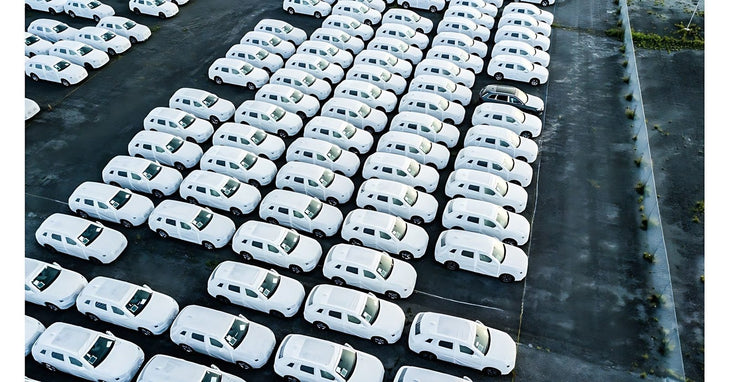 Vue aerienne de vehicules utilitaires blancs alignes sur un parc de flotte automobile d entreprise