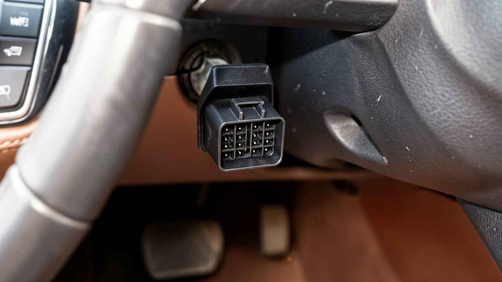 Gros plan sur l emplacement de la prise diagnostic OBD2 noire sous le tableau de bord d une voiture