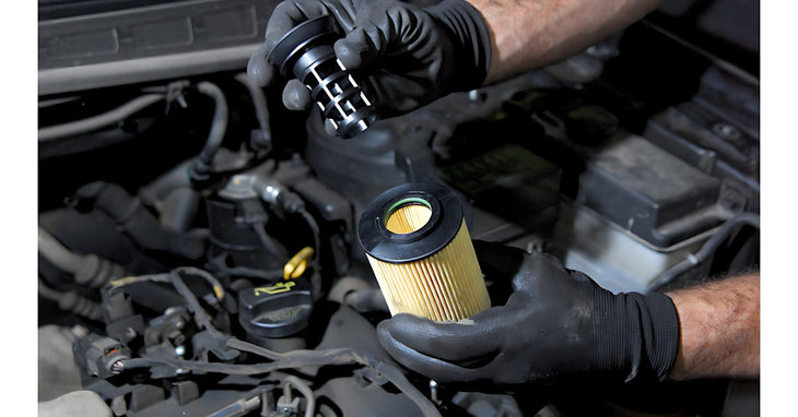Mecanicien gante deposant un filtre a particules diesel pour un nettoyage en profondeur