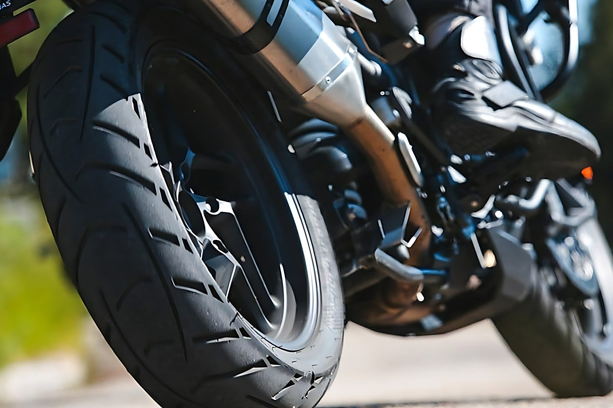 Gros plan sur le pneu arriere et l echappement d une moto lancee sur route