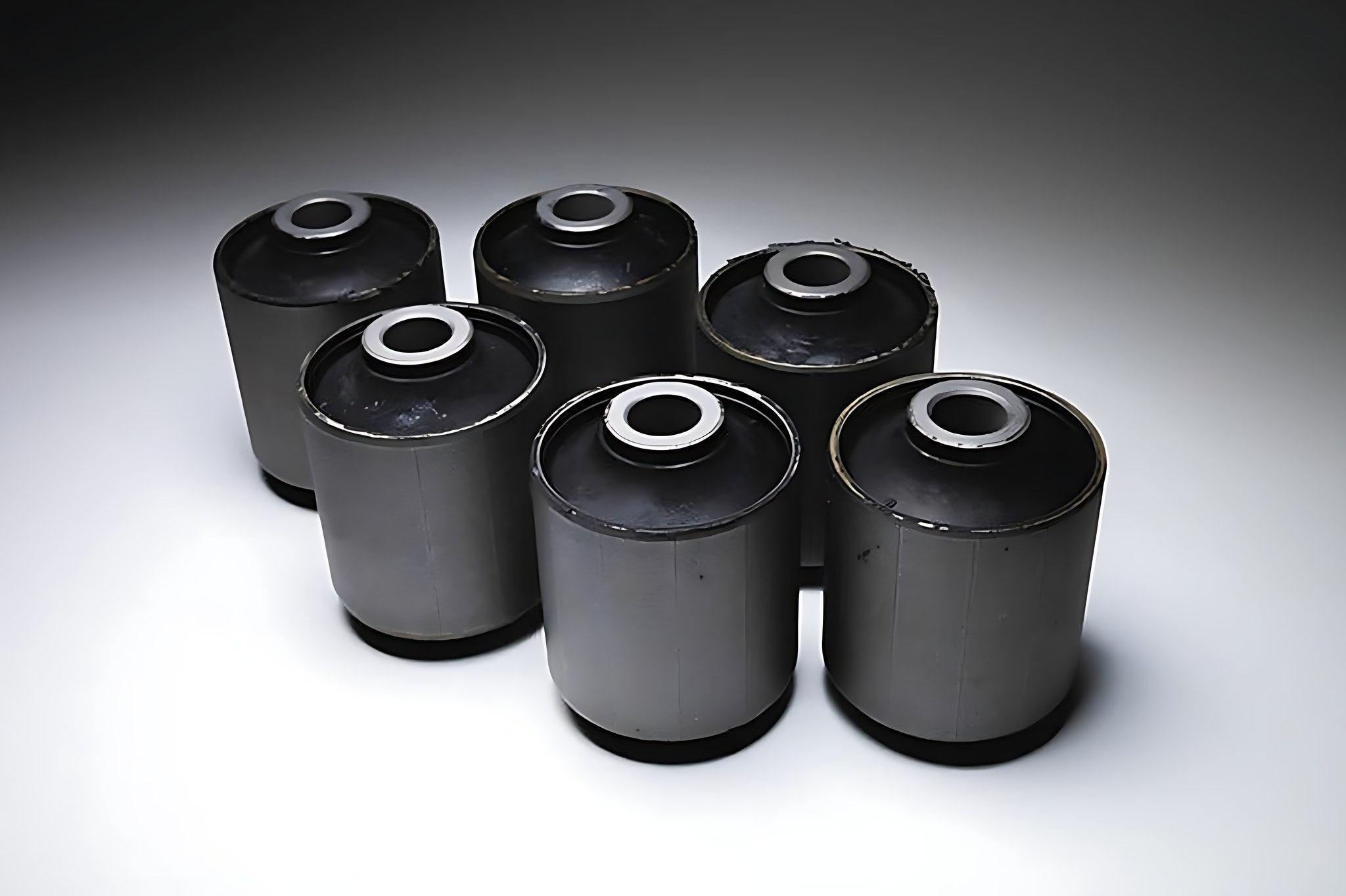 Lot de six silent blocs de suspension automobile neufs poses sur un fond blanc