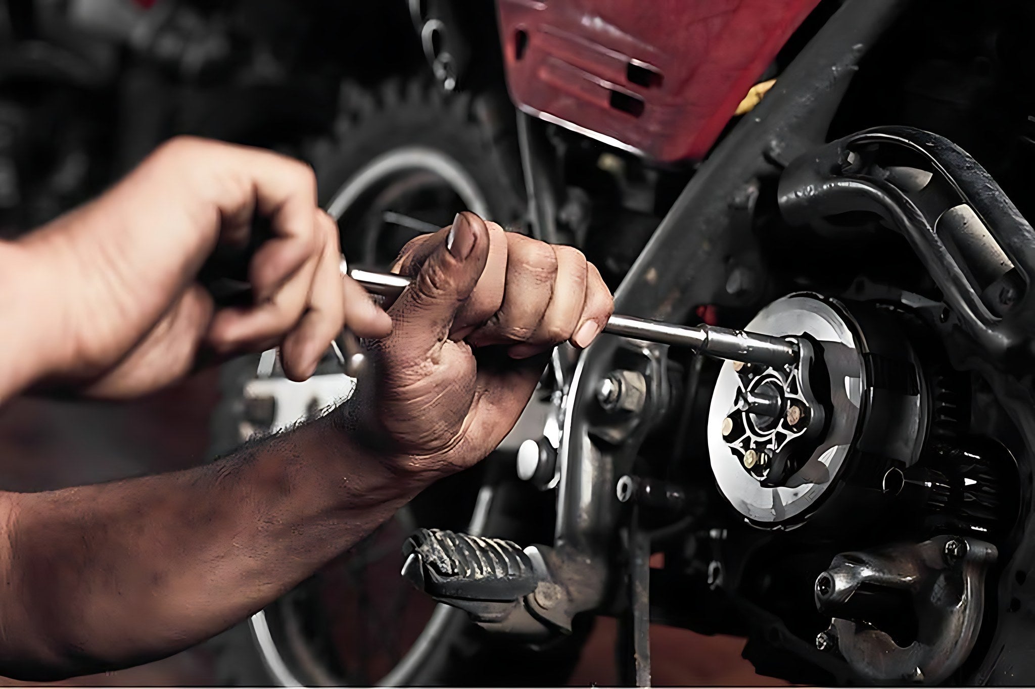 Mecanicien reparant l embrayage d une moto en atelier avant le controle technique