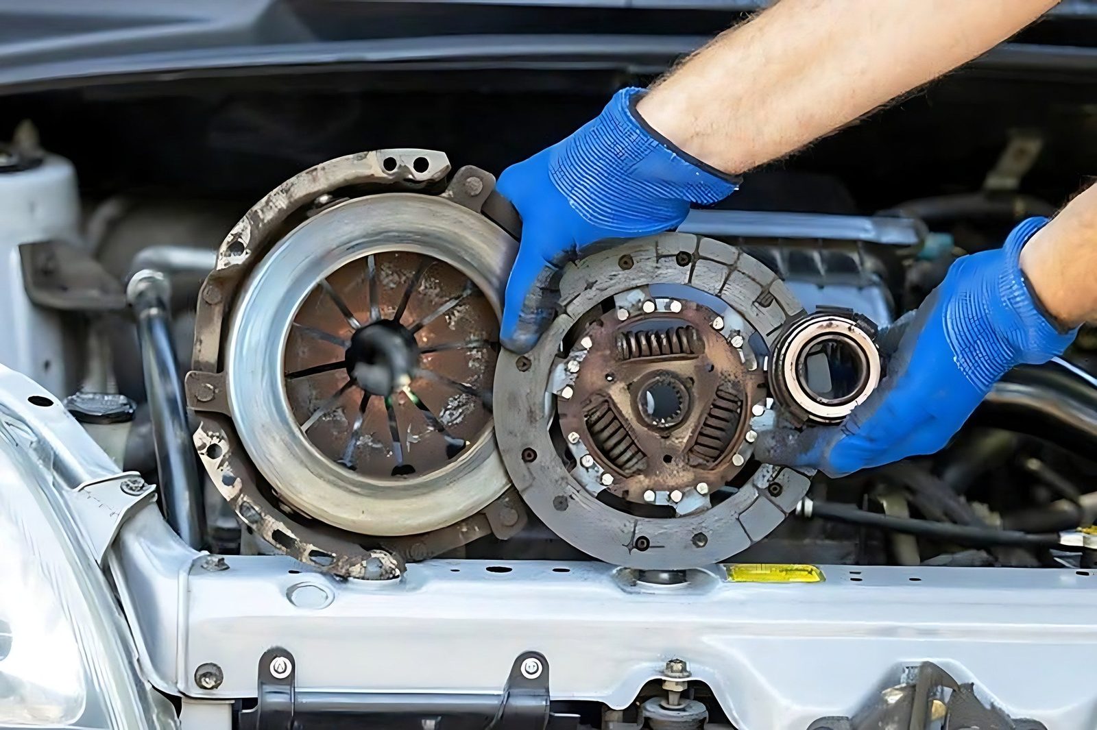 Mains d un mecanicien tenant les pieces d un embrayage hydraulique de voiture