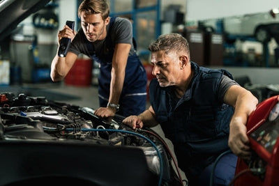 Deux mecaniciens inspectent le moteur d une voiture avec une valise de diagnostic auto