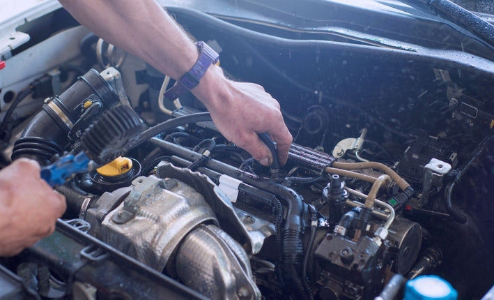 Mécanicien travaillant sur le moteur d une voiture pour estimer le prix du changement de turbo