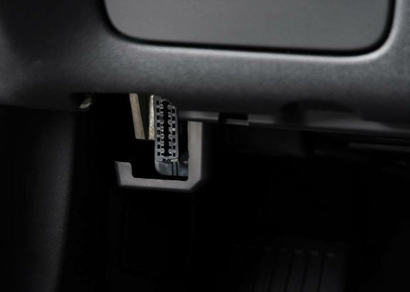 Gros plan sur l emplacement de la prise diagnostic OBD2 noire sous le tableau de bord d une voiture