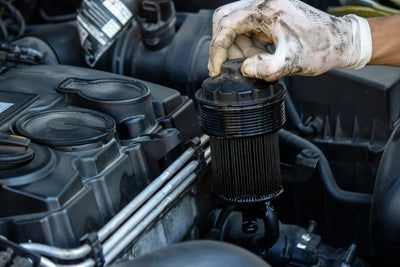 Mécanicien retirant un filtre à essence usagé du moteur lors de la vidange