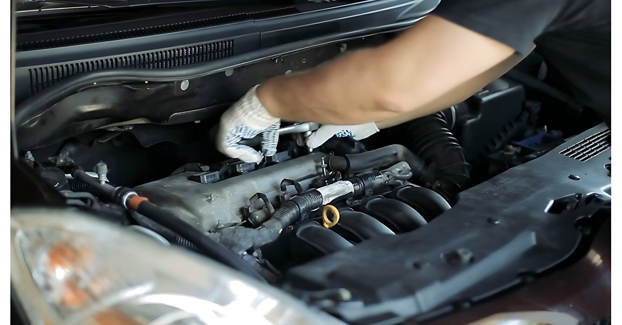 Mecanicien travaillant sur le moteur d une voiture au capot ouvert dans un atelier professionnel