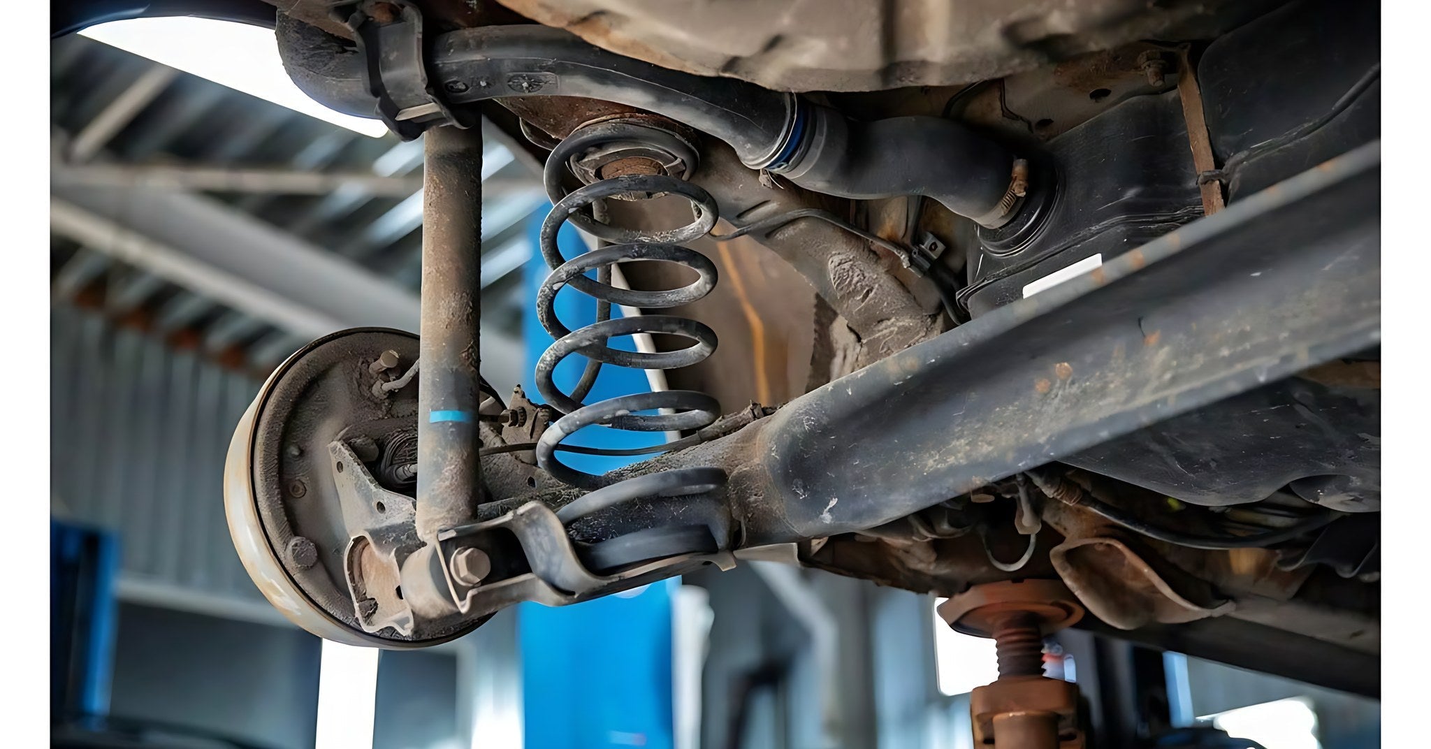 Vue sous un vehicule avec un ressort de suspension et un amortisseur de voiture uses