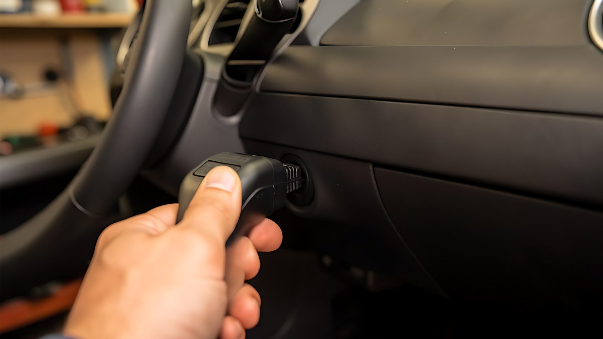 Technicien branchant une valise de diagnostic iCarsoft sur la prise OBD2 sous le tableau de bord