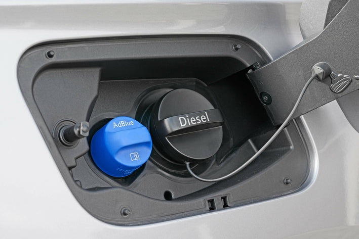 Détail de la trappe à carburant avec le bouchon de réservoir diesel et le bouchon bleu d'AdBlue