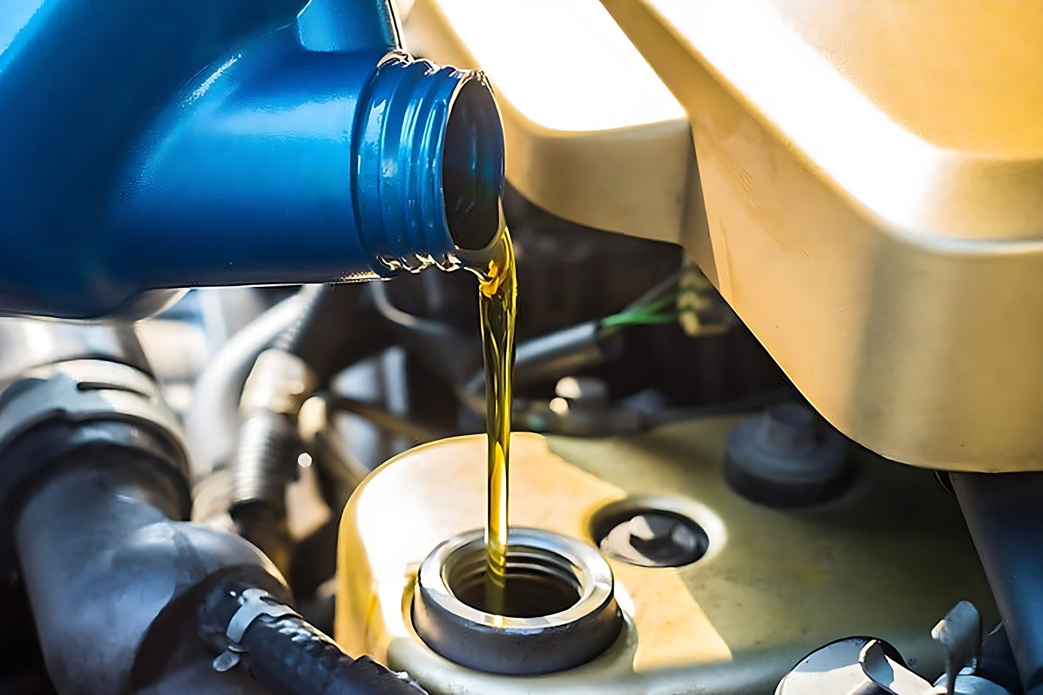 Versement huile moteur neuve lors une vidange de voiture en atelier