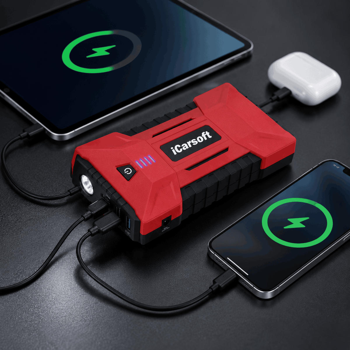 Batterie externe rouge iCarsoft rechargeant simultanément une tablette un smartphone et des écouteurs