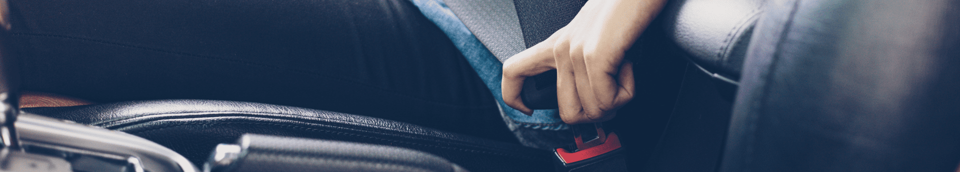 Gros plan sur un conducteur qui boucle sa ceinture de sécurité en voiture