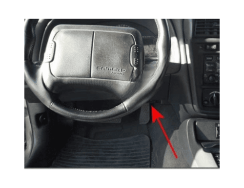 Tableau de bord et volant de Chevrolet Camaro avec flèche rouge pointant vers le connecteur OBD