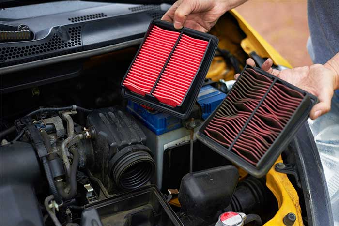 Comparaison entre un filtre à air neuf rouge et un filtre usagé encrassé pour l'entretien d'une voiture