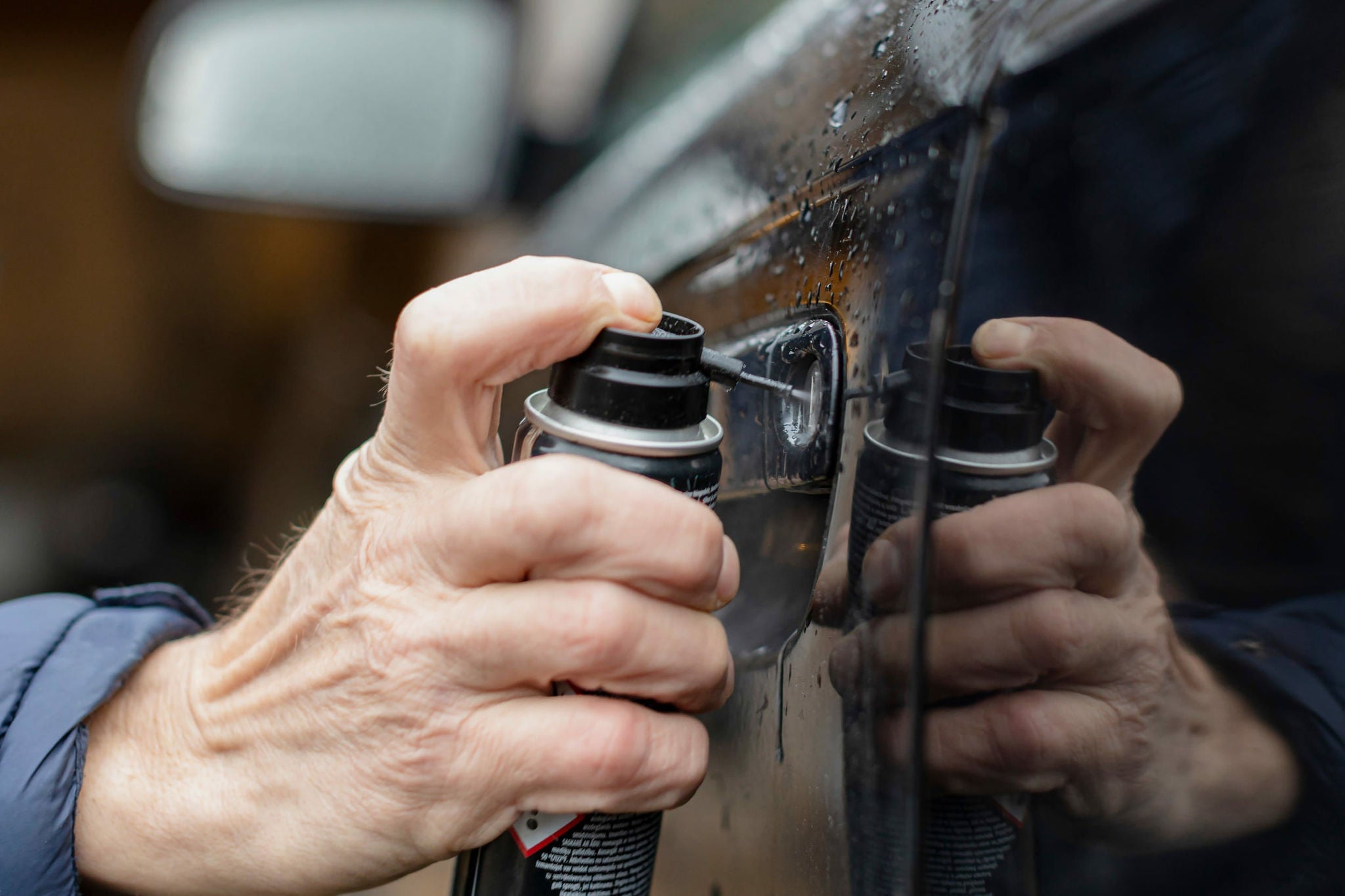 Lubrification de la serrure d'une portiere de voiture gelee en hiver avec un spray aerosol