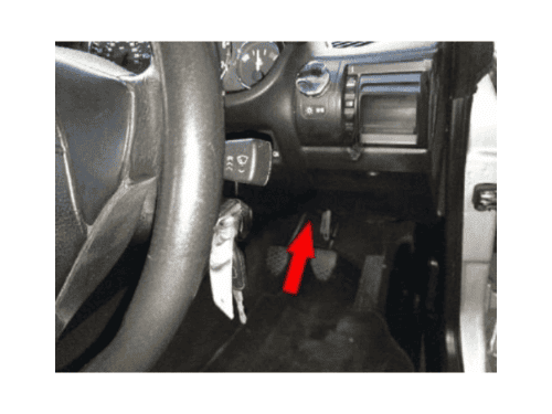 Fleche rouge indiquant l emplacement de la prise OBD sous le volant d une BMW Z3 conduite a droite