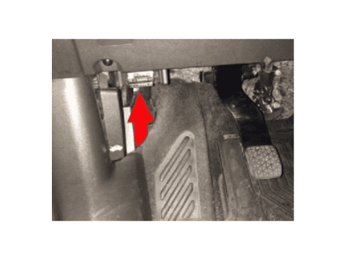 Flèche rouge montrant l'emplacement exact de la prise OBD sous le volant d'une Chevrolet Trax