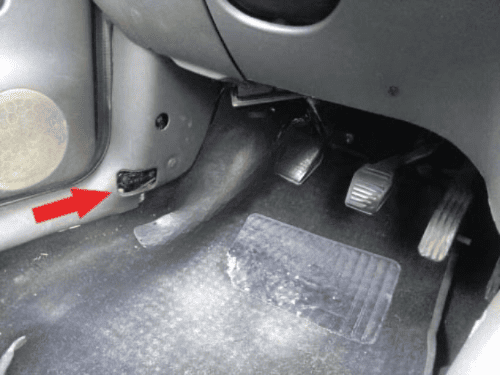 Fleche rouge indiquant l emplacement de la prise OBD sur le montant de porte d une Ford Fiesta 4