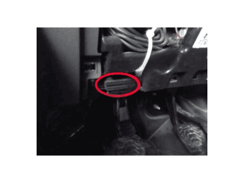 Emplacement de la prise de diagnostic OBD entouré en rouge sous le volant d'un Ford Transit