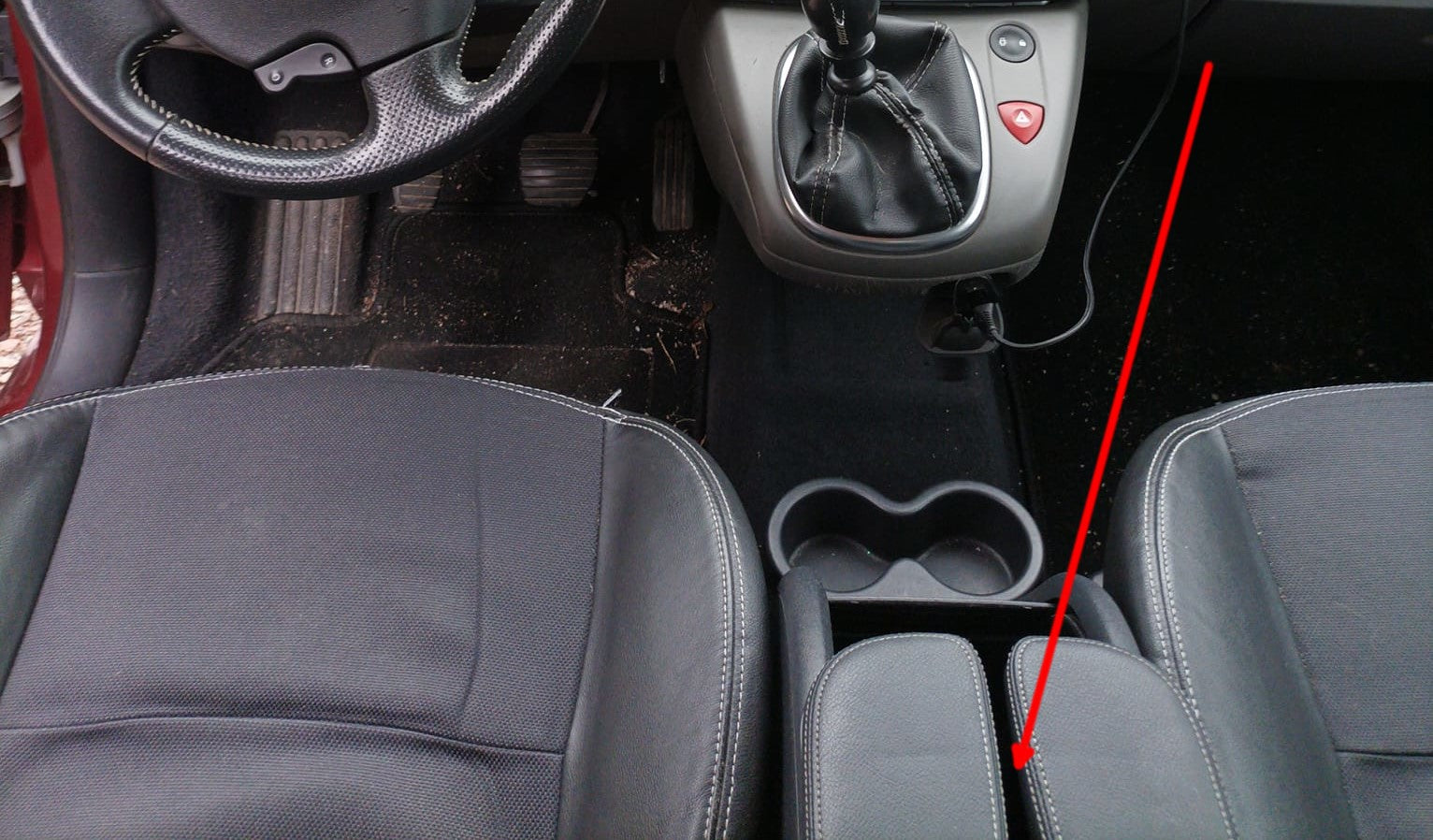 Fleche rouge indiquant l emplacement du port de diagnostic OBD sous l accoudoir central d une Renault Scenic 3