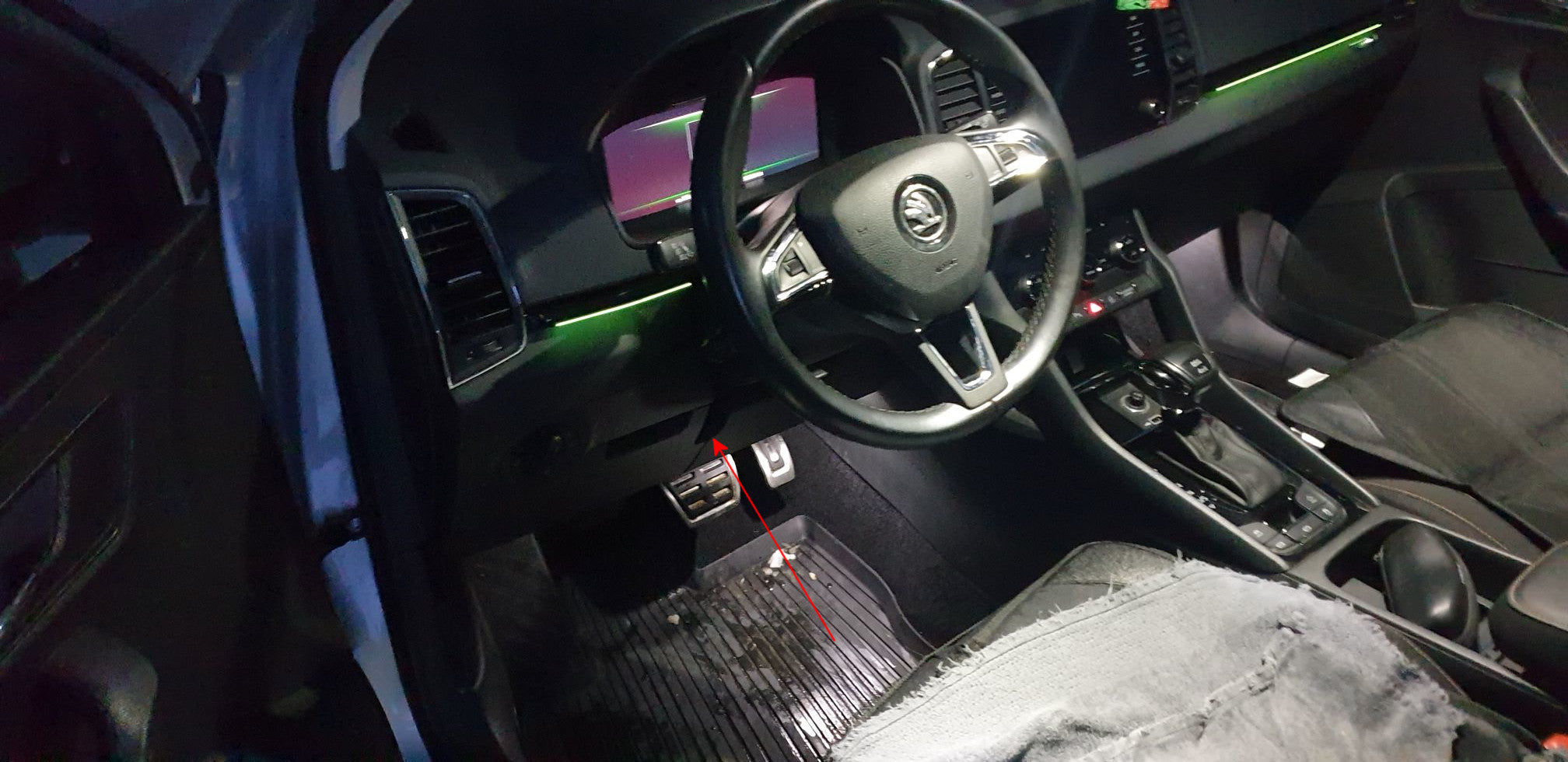 Une flèche rouge indique l emplacement de la prise OBD sous le tableau de bord d une Skoda pour brancher une valise