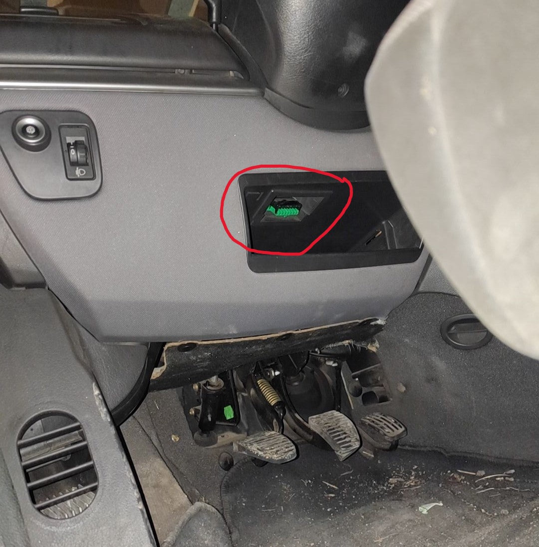 Prise de diagnostic OBD2 verte repérée sous le volant d une voiture pour brancher un appareil iCarsoft