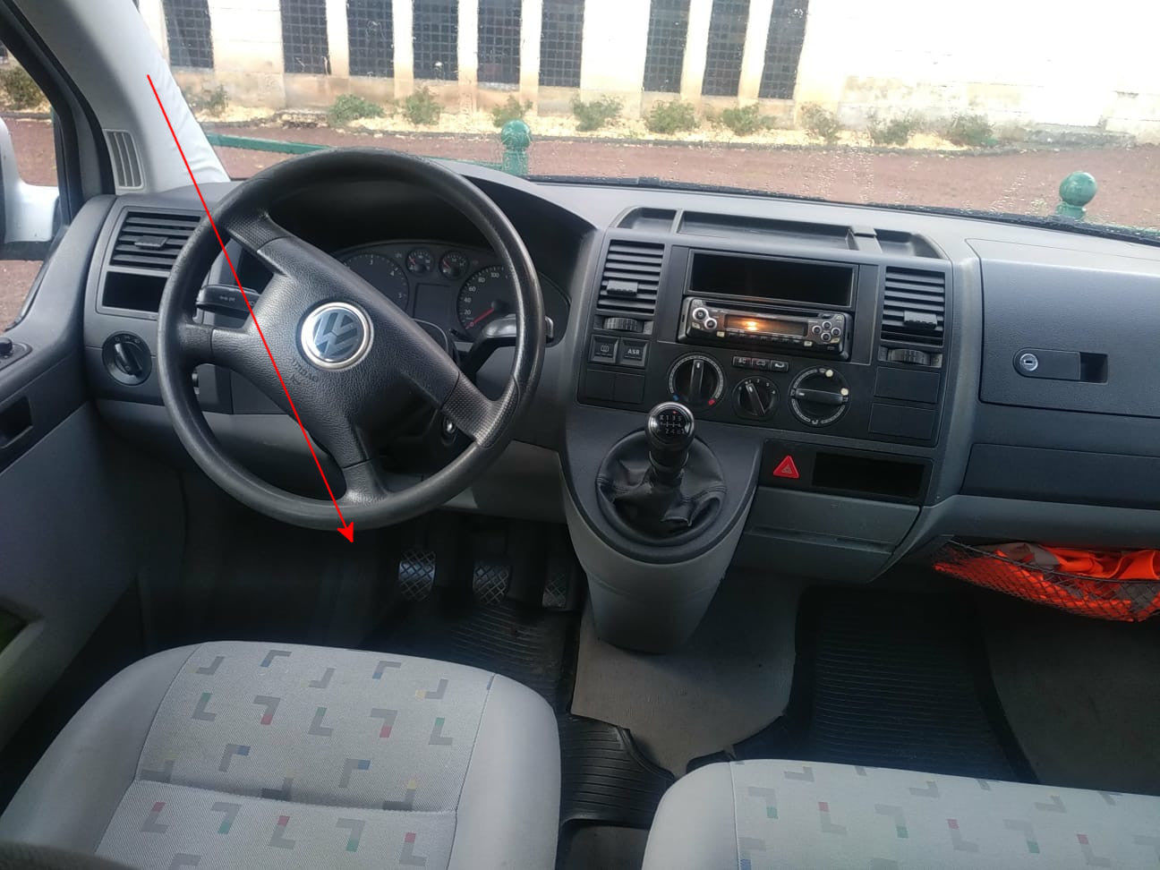 Fleche rouge indiquant l emplacement de la prise OBD sous le volant d un Volkswagen T5