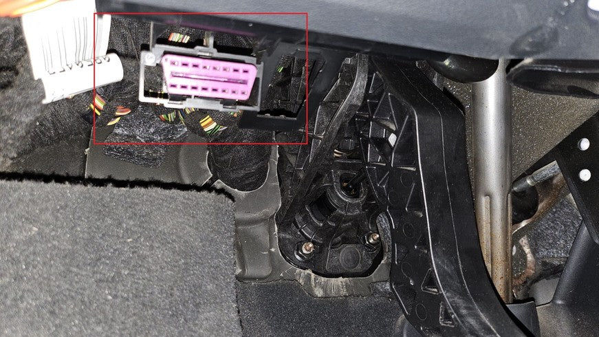 Prise de diagnostic OBD2 violette localisée sous le tableau de bord d une Audi Q3