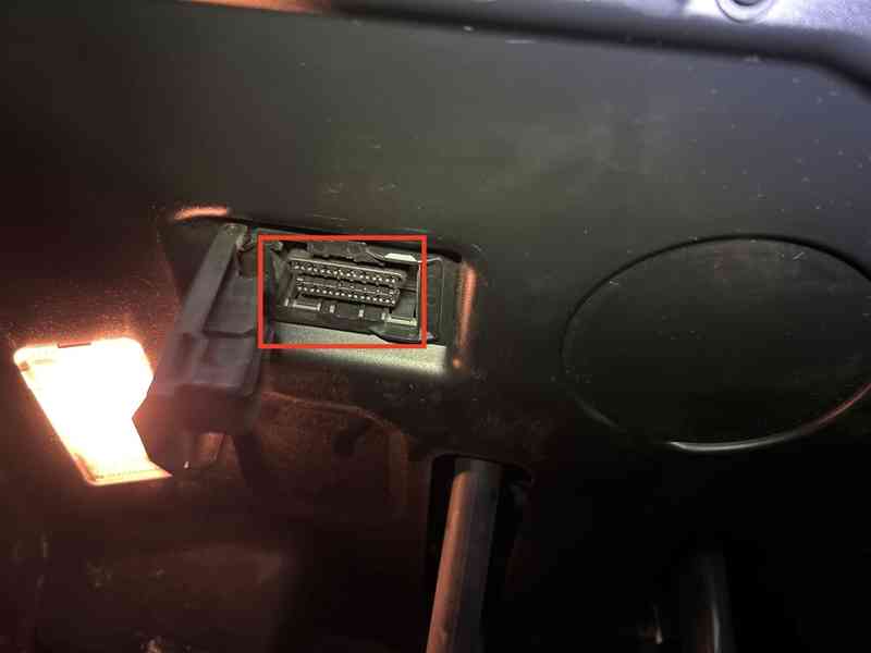 Gros plan sur l emplacement de la prise OBD2 d une BMW Serie 3 E46 sous le tableau de bord