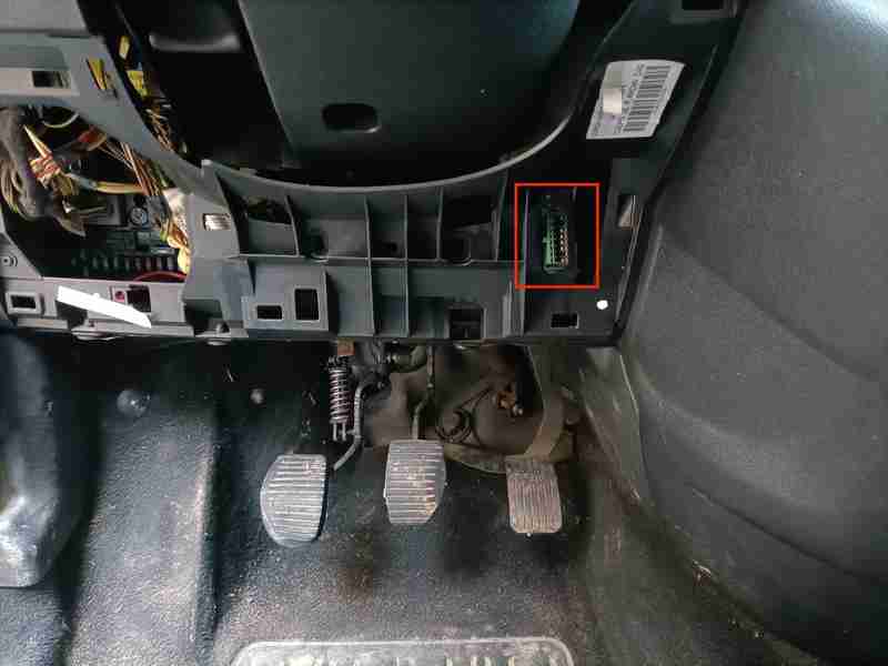 Emplacement de la prise OBD2 encadrée en rouge sous le volant d un Citroën Berlingo