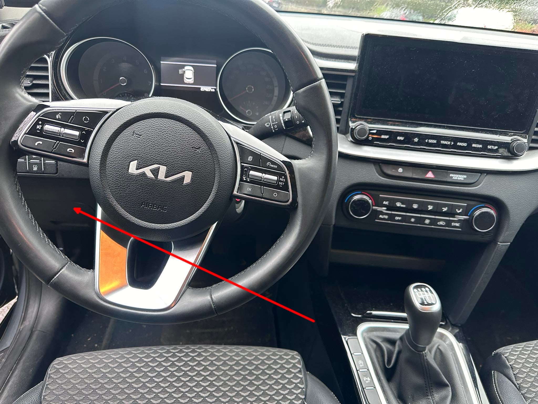 Localisation de la prise de diagnostic OBD2 sous le volant d'une voiture Kia