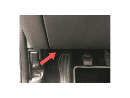 Emplacement de la prise OBD au niveau du pédalier d'une Ford Cougar avec flèche de repérage