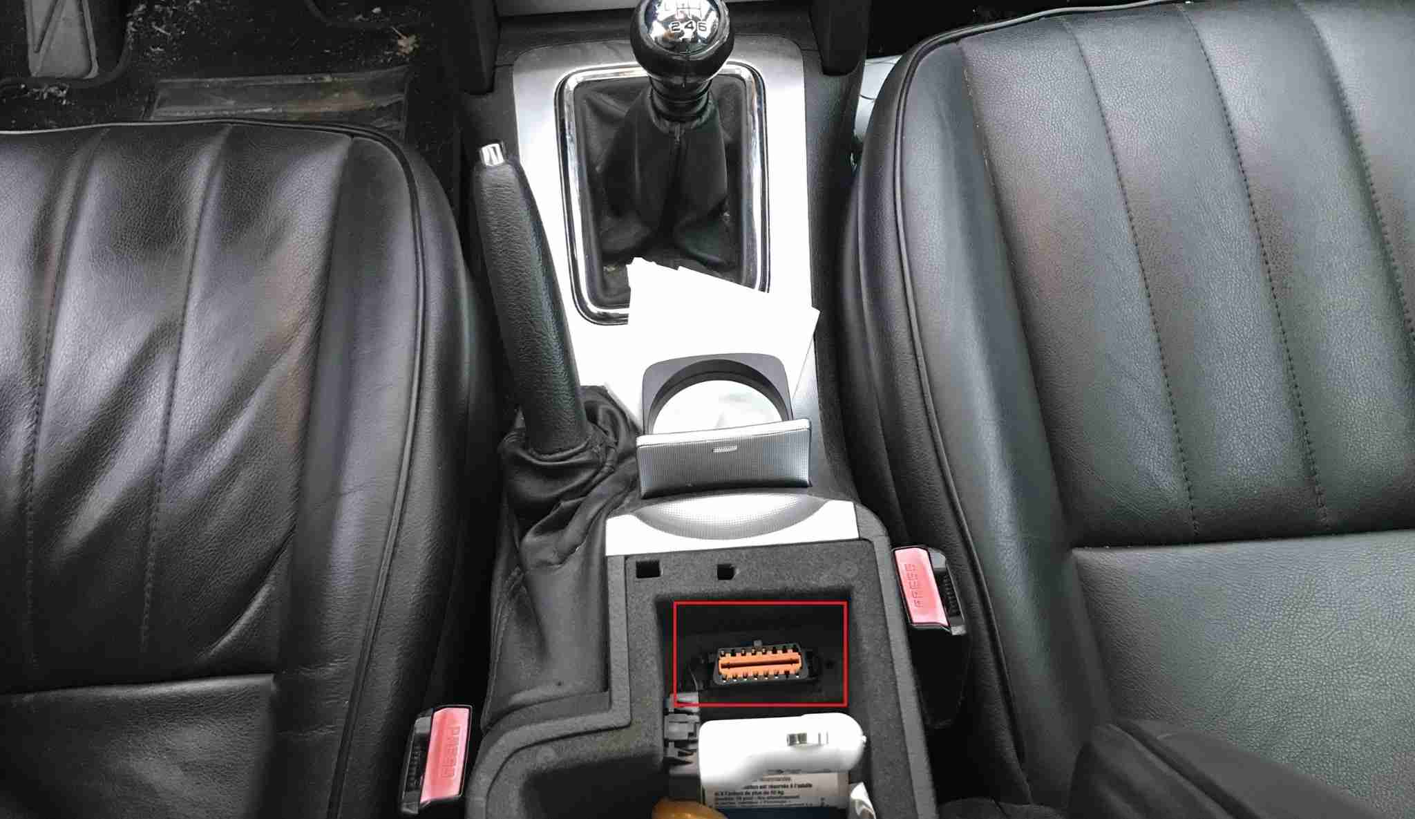 Emplacement de la prise OBD2 de diagnostic sous l accoudoir d une Peugeot 407