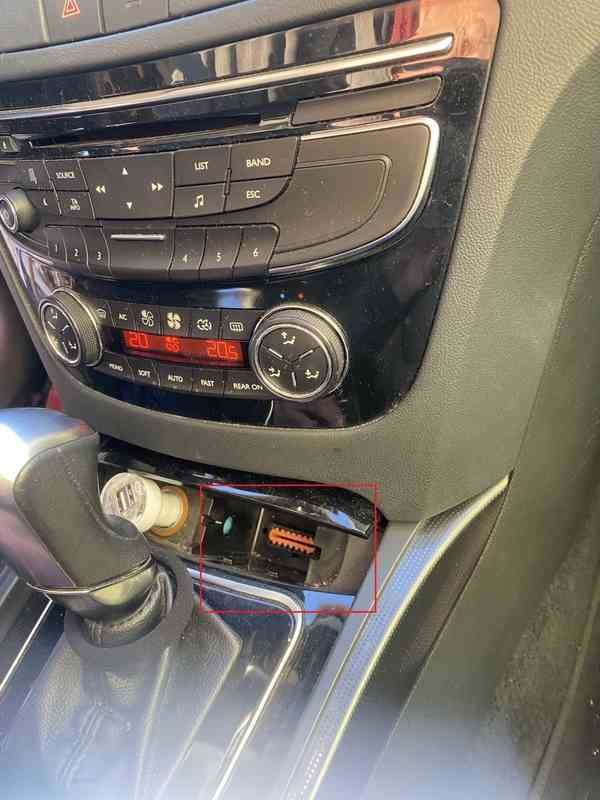 Emplacement de la prise de diagnostic OBD2 orange sur une Peugeot 508 sous la console centrale