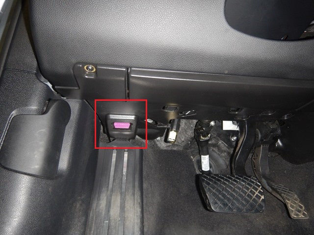 Localisation de la prise de diagnostic OBD2 violette sous le tableau de bord