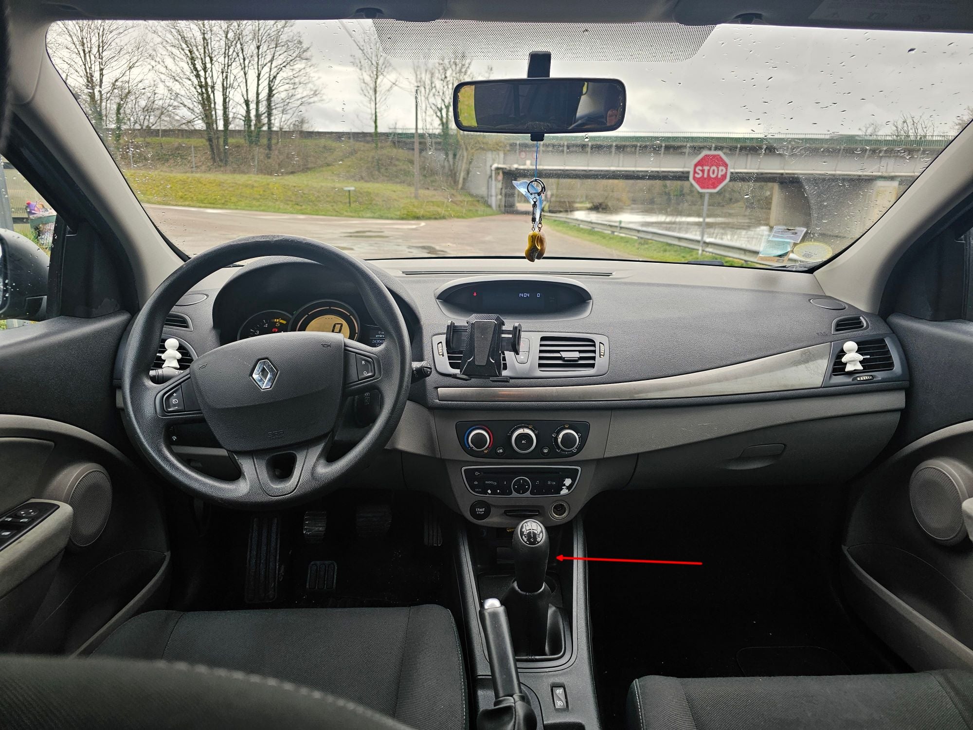 Vue intérieure du tableau de bord montrant l'emplacement de la prise OBD2 sur Renault Mégane 3
