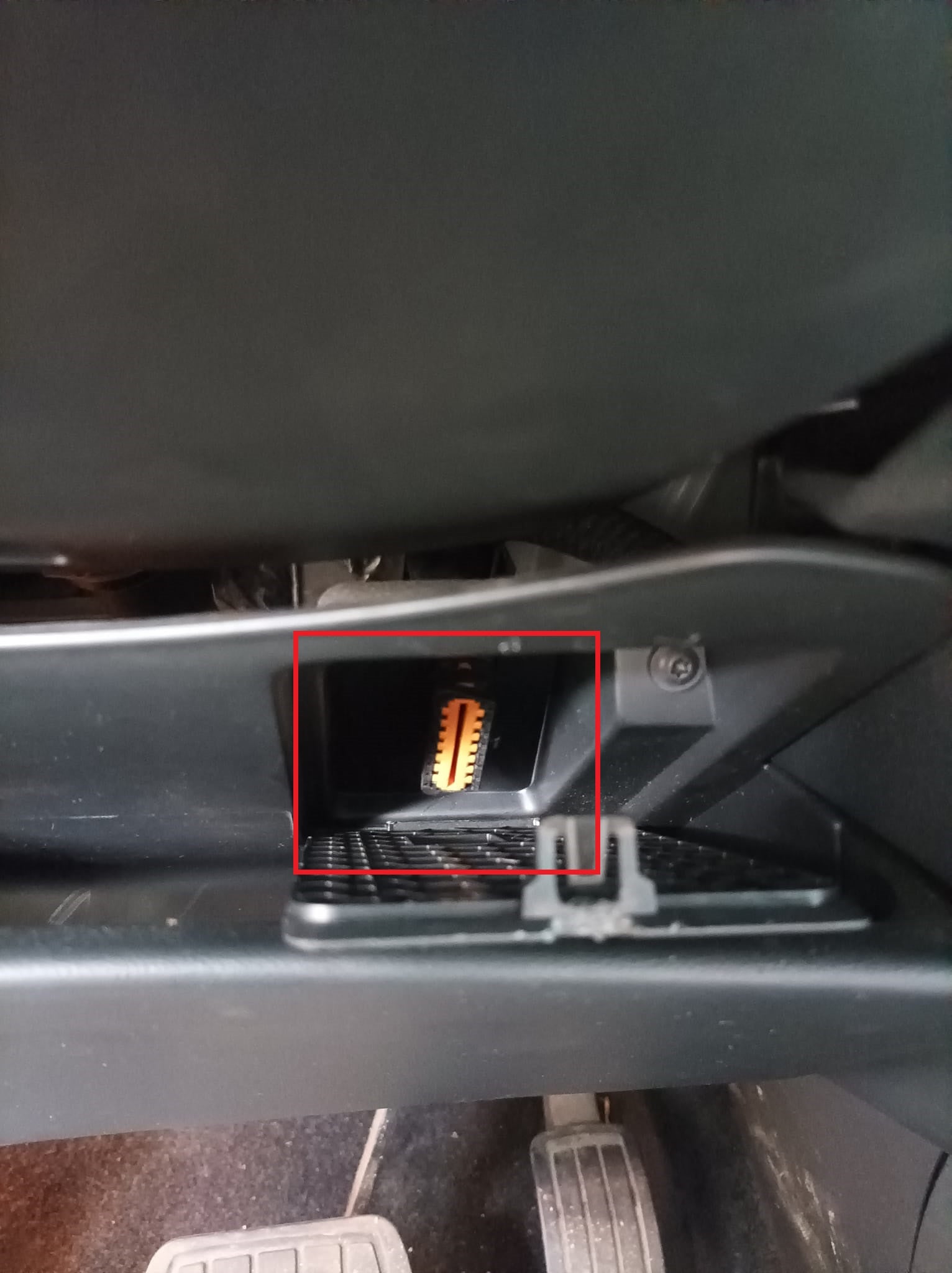 Emplacement de la prise de diagnostic OBD2 orange sous le tableau de bord