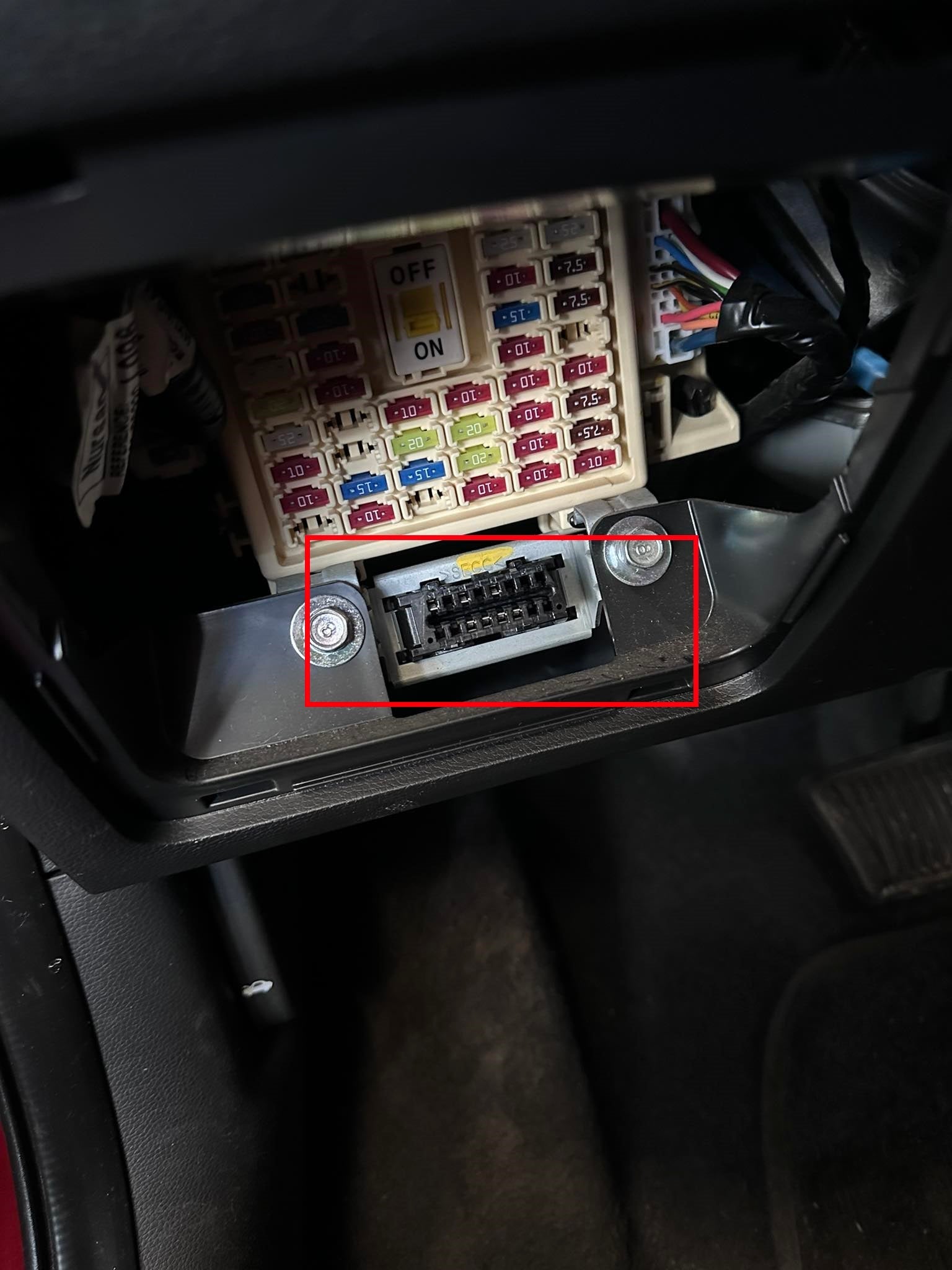 Localisation de la prise de diagnostic OBD2 sous la boîte à fusibles d'un véhicule