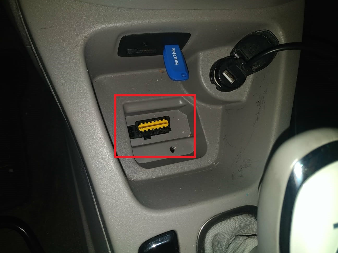 Prise de diagnostic OBD jaune situee dans la console centrale d un vehicule