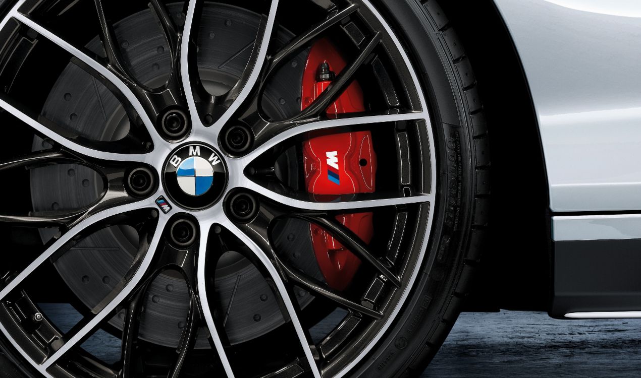 Gros plan sur un étrier de frein rouge de marque BMW M derrière une jante sport bicolore