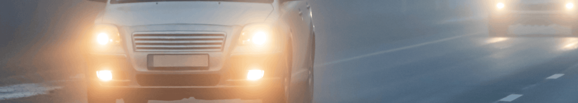 Voiture roulant dans le brouillard épais avec ses phares et feux de brouillard allumés