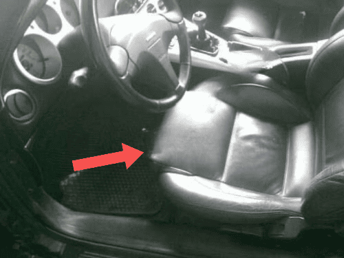 Habitacle dune Fiat Barchetta avec fleche rouge indiquant la prise de diagnostic OBD