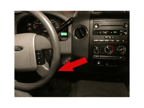 Tableau de bord et volant d un Ford F150 avec flèche rouge indiquant l emplacement de prise OBD