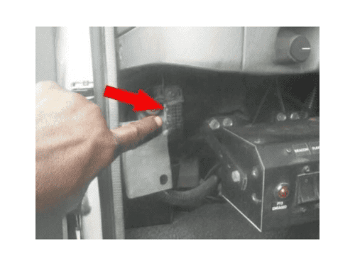 Doigt montrant l emplacement de la prise OBD sur le tableau de bord d un camion Ford LCF