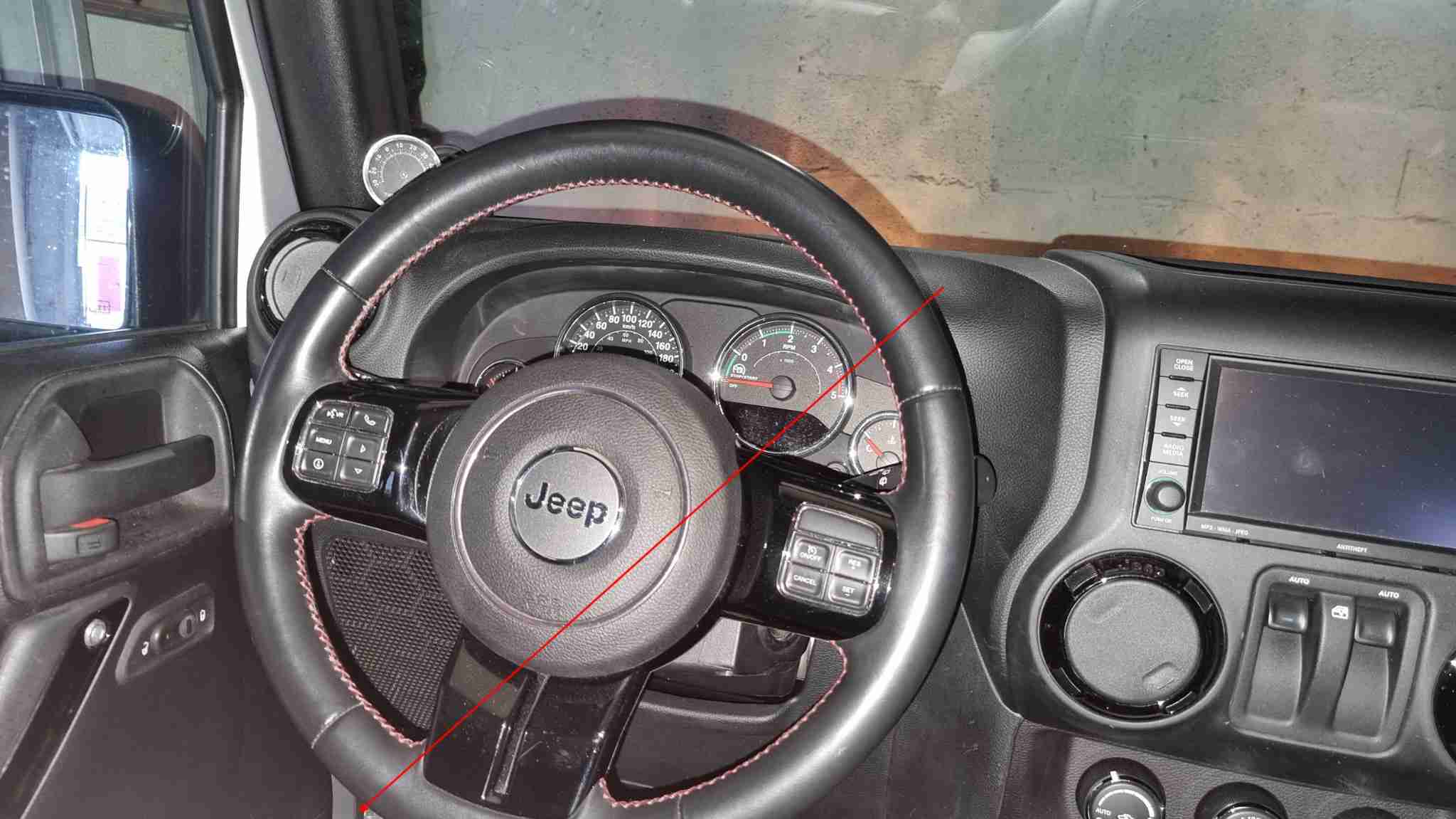 Volant en cuir noir et tableau de bord complet dans l habitacle d une Jeep Wrangler JK